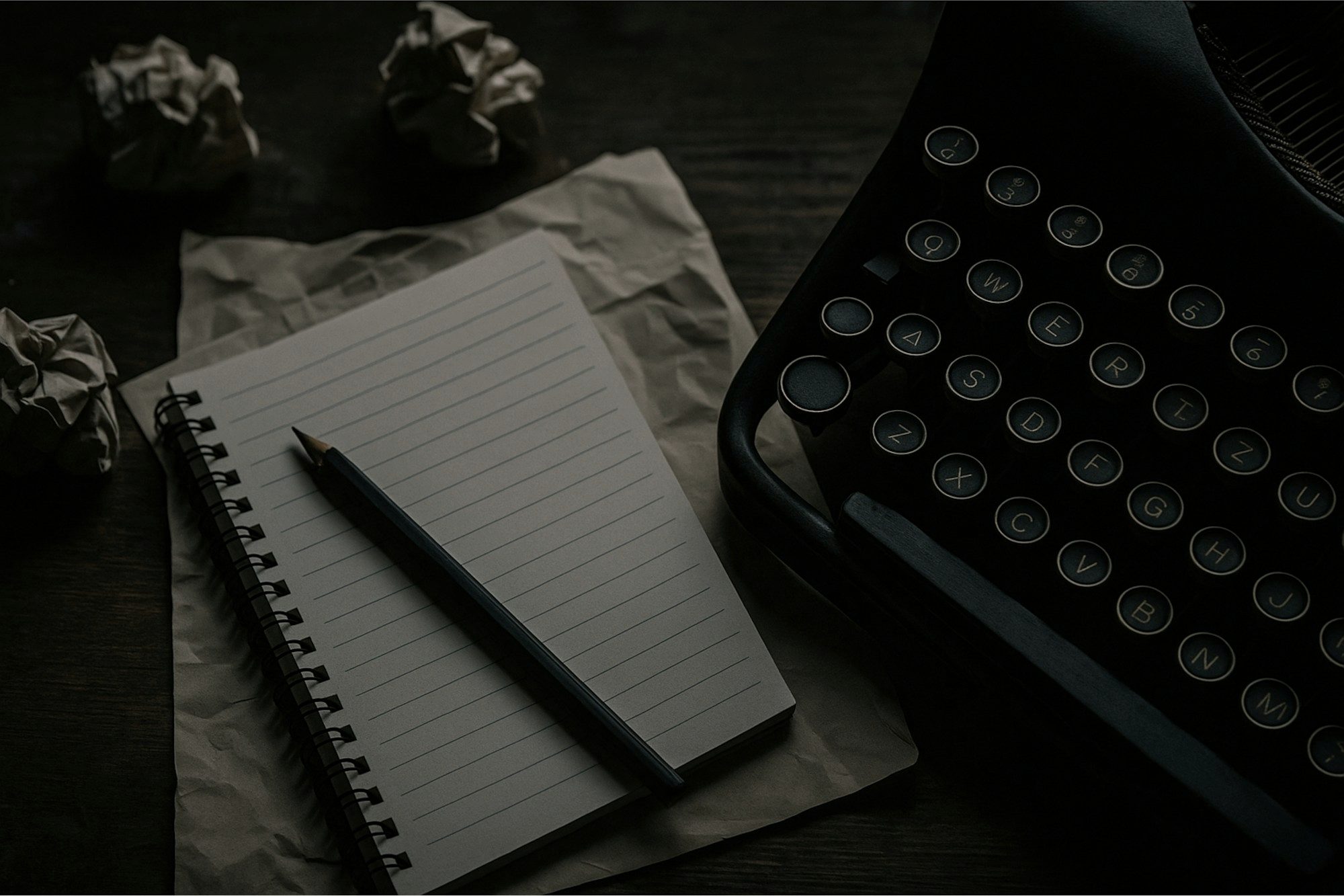 A notepad and pen beside a typewriter